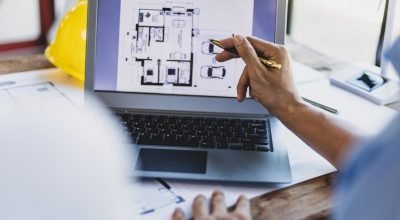 brainstorming-group-architects-engineers-discuss-building-blueprint-design-laptop-construction-project-planning-wooden-table-office (1)