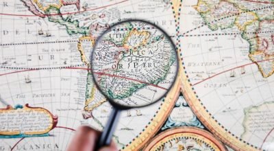 person-holding-magnifying-glass-map-showing-peruvian-cities (1)
