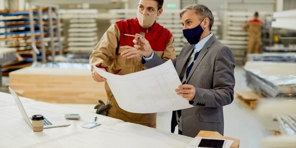 project-manager-carpenter-examining-design-plans-woodworking-facility (1)